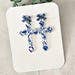 Floral Cross Dangle Earrings: Blue Bow Accent